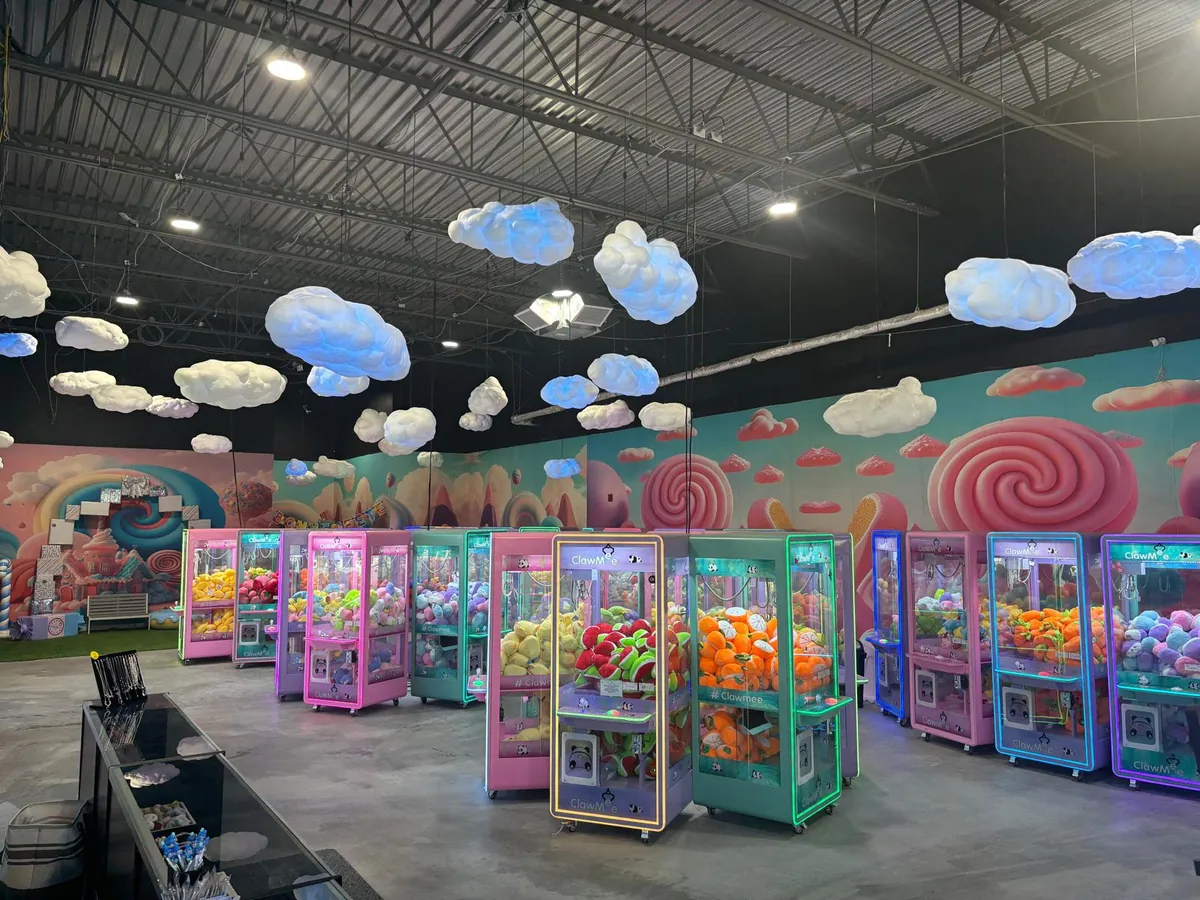 Allée de machines à pince ClawMee avec nuages lumineux au plafond