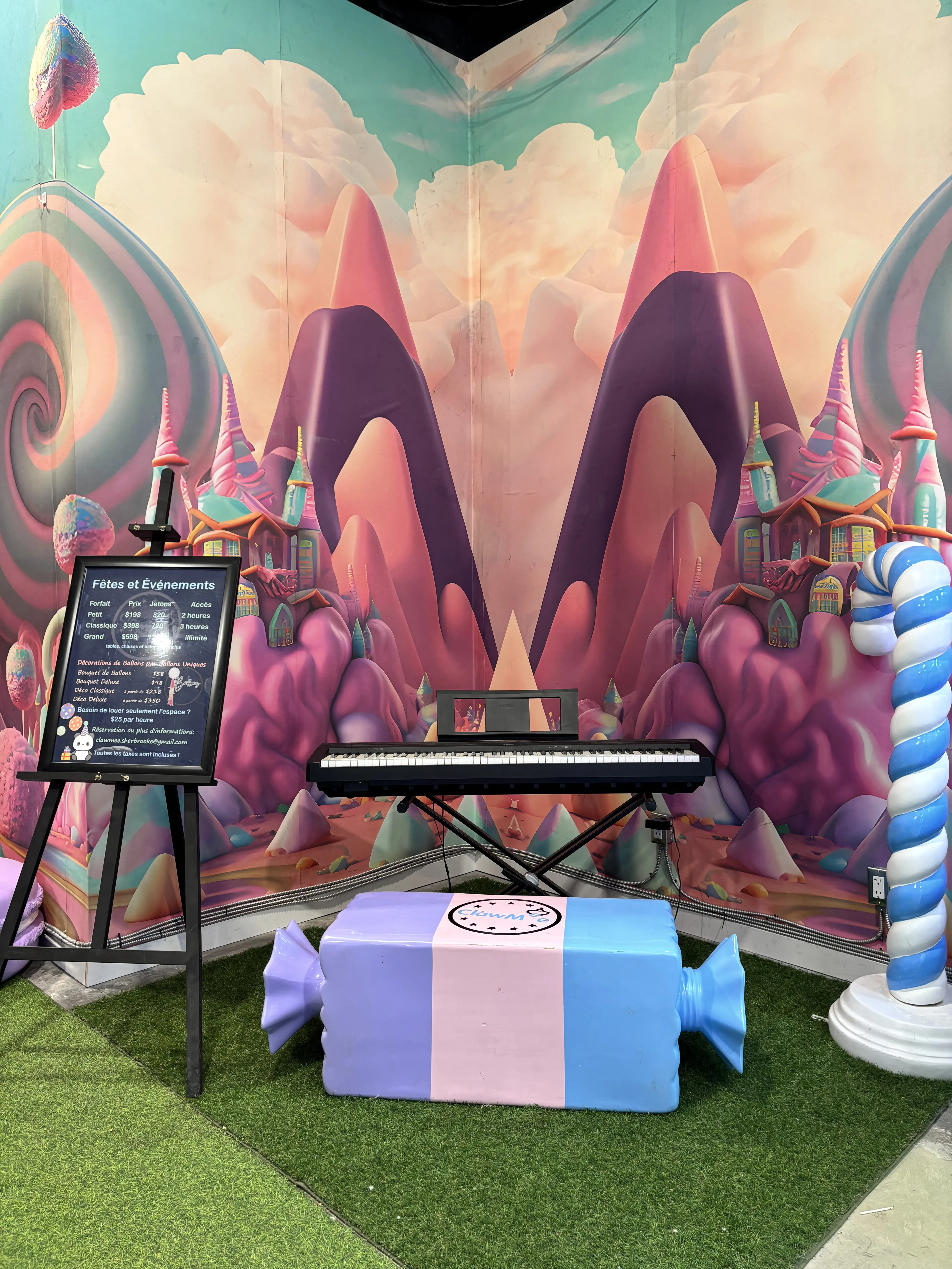 Coin candyland avec piano et banc en forme de bonbon devant la murale de montagnes sucrées