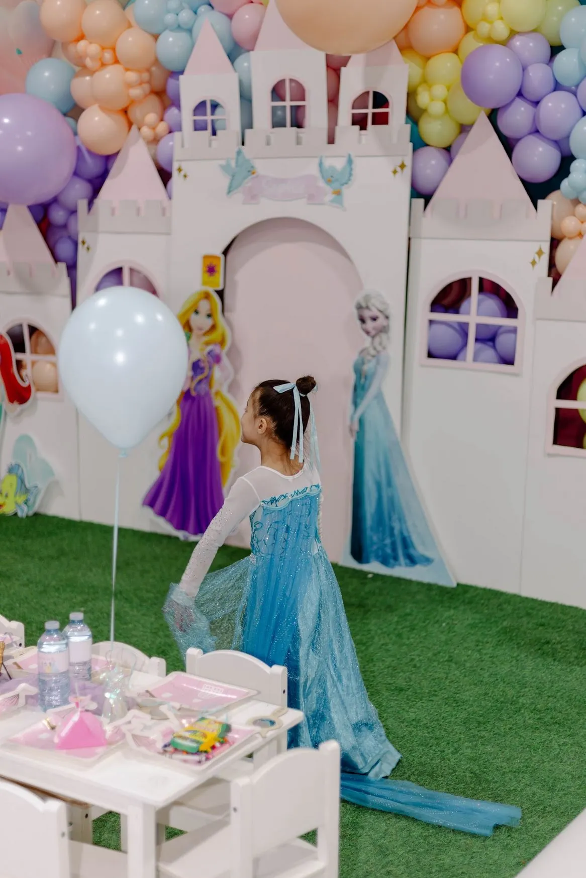 Enfant en robe de princesse devant le château de fête décoré chez ClawMee Sherbrooke