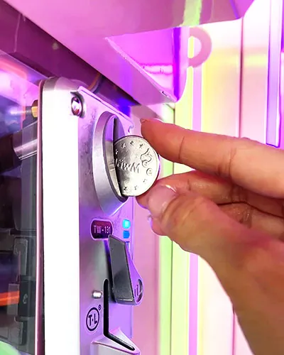 Jeton ClawMee inséré dans une machine à pince